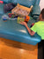 a young boy in yellow shirt plays with his connetix set on a blue lounge