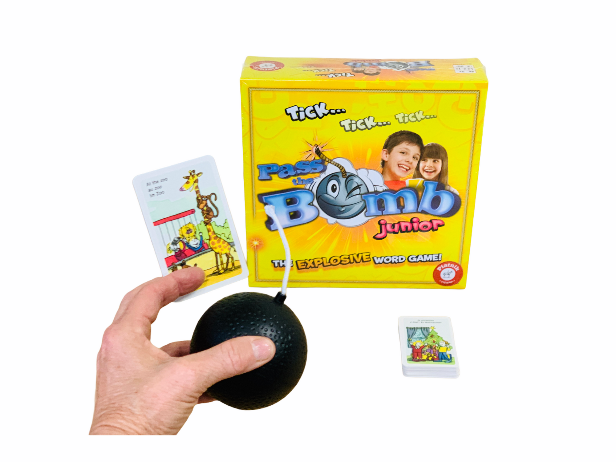 a person holding the bomb from the Pass The Bomb Junior game in front of box and cards