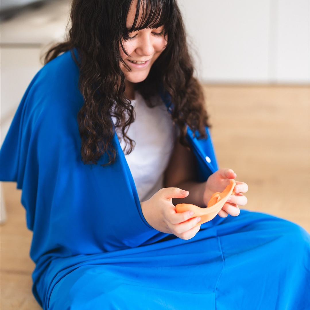A woman wearing the Starfish Premium Lycra Body Sock and playing with Therapy putty from Starfish
