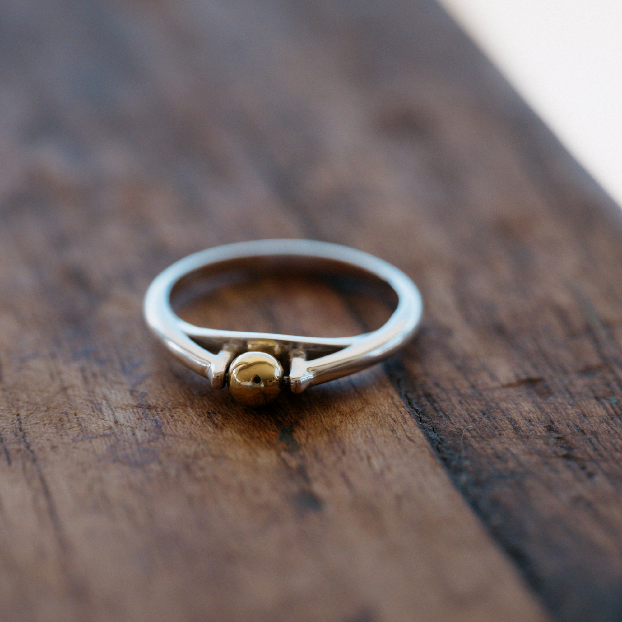 The Star &amp; Co Anxiety Jewellery - The India Ring sitting on a wooden bench