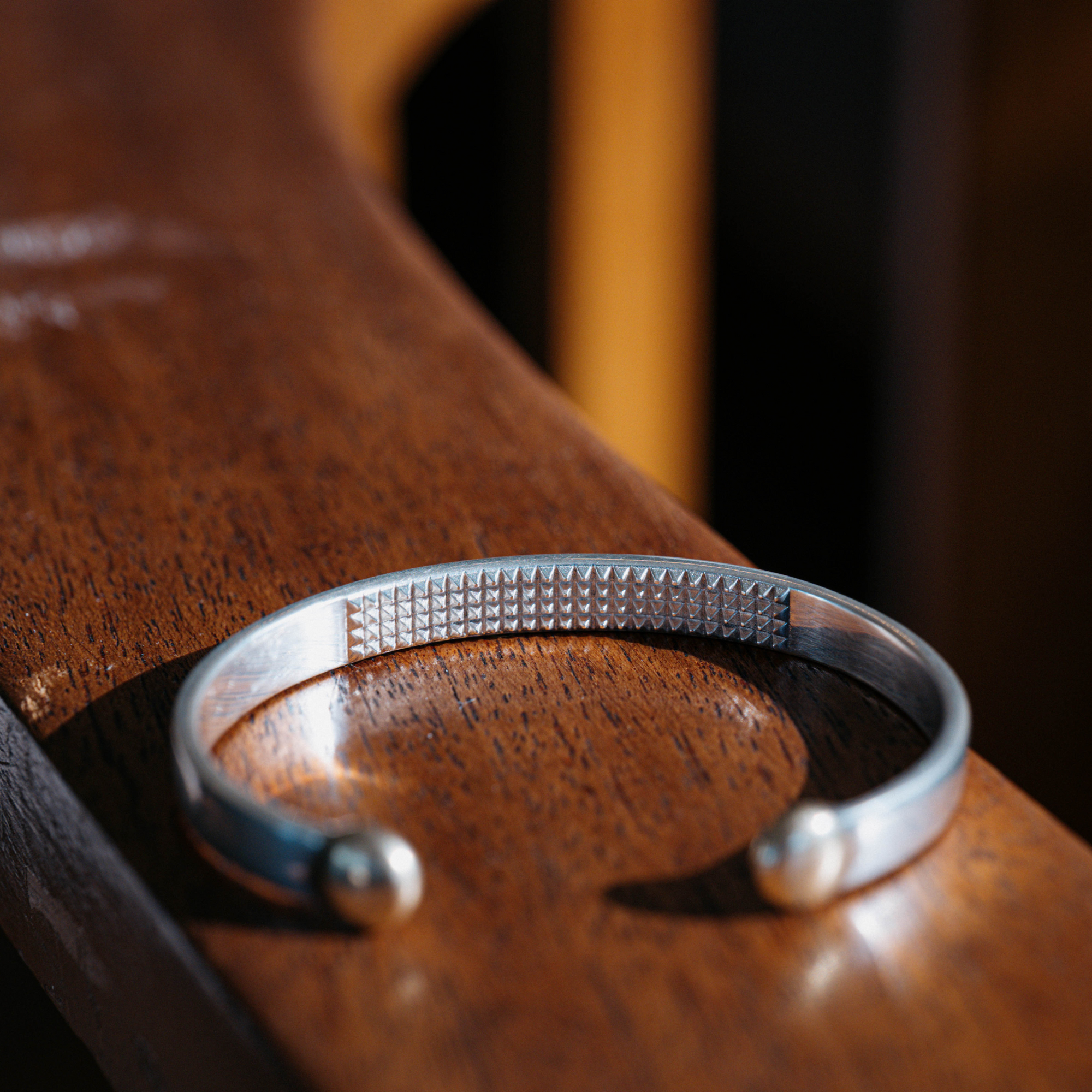 The Star &amp; Co Anxiety Jewellery - The Annika Cuff resting on a timber handrail