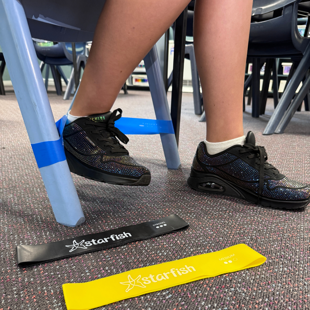 Person using resistance bands on a classroom chair with 'Starfish' branding.