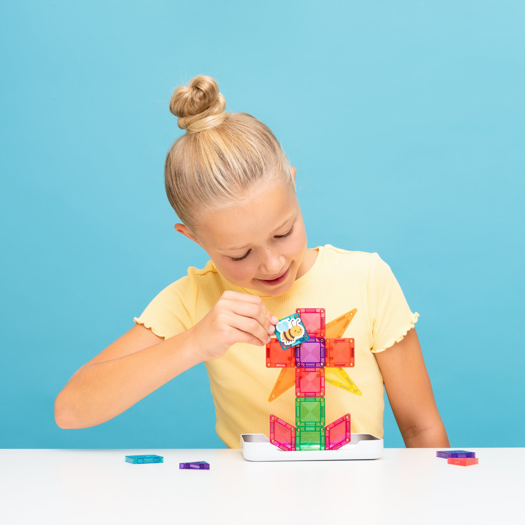 A young girl playing with the Connetix Tiles - Travel Mini Pack 32pc