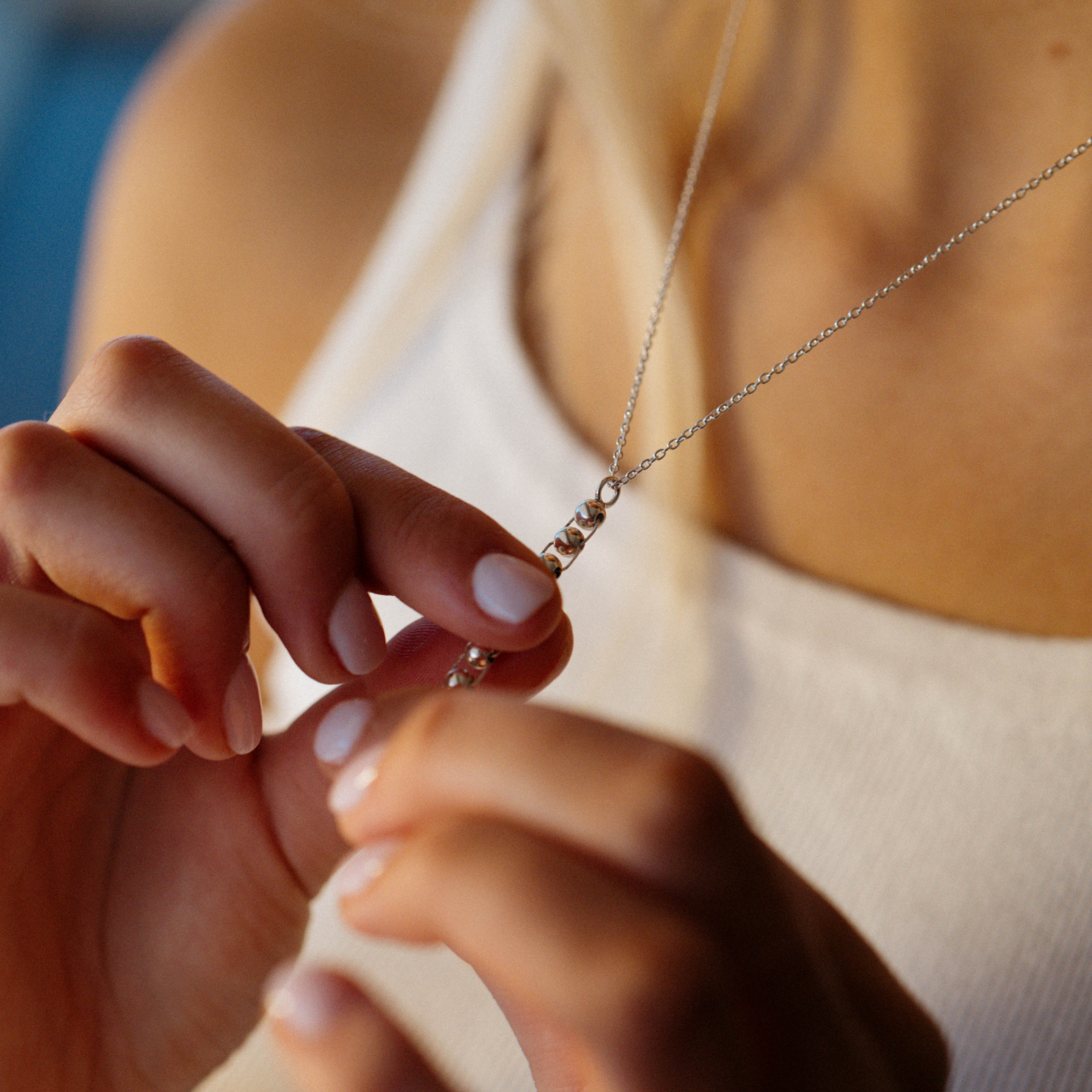 a girl playing with the Star &amp; Co Anxiety Jewellery - The Flor Necklace