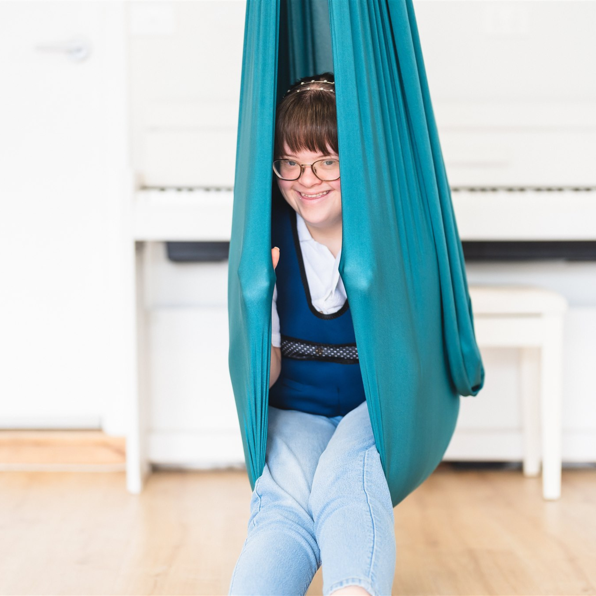 A woman sitting in the Deluxe Compression Sensory Swing