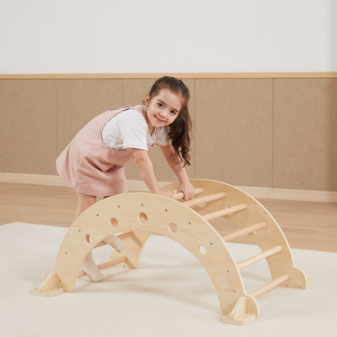 young girl climbing on the VIGA Wooden Climbing Arch