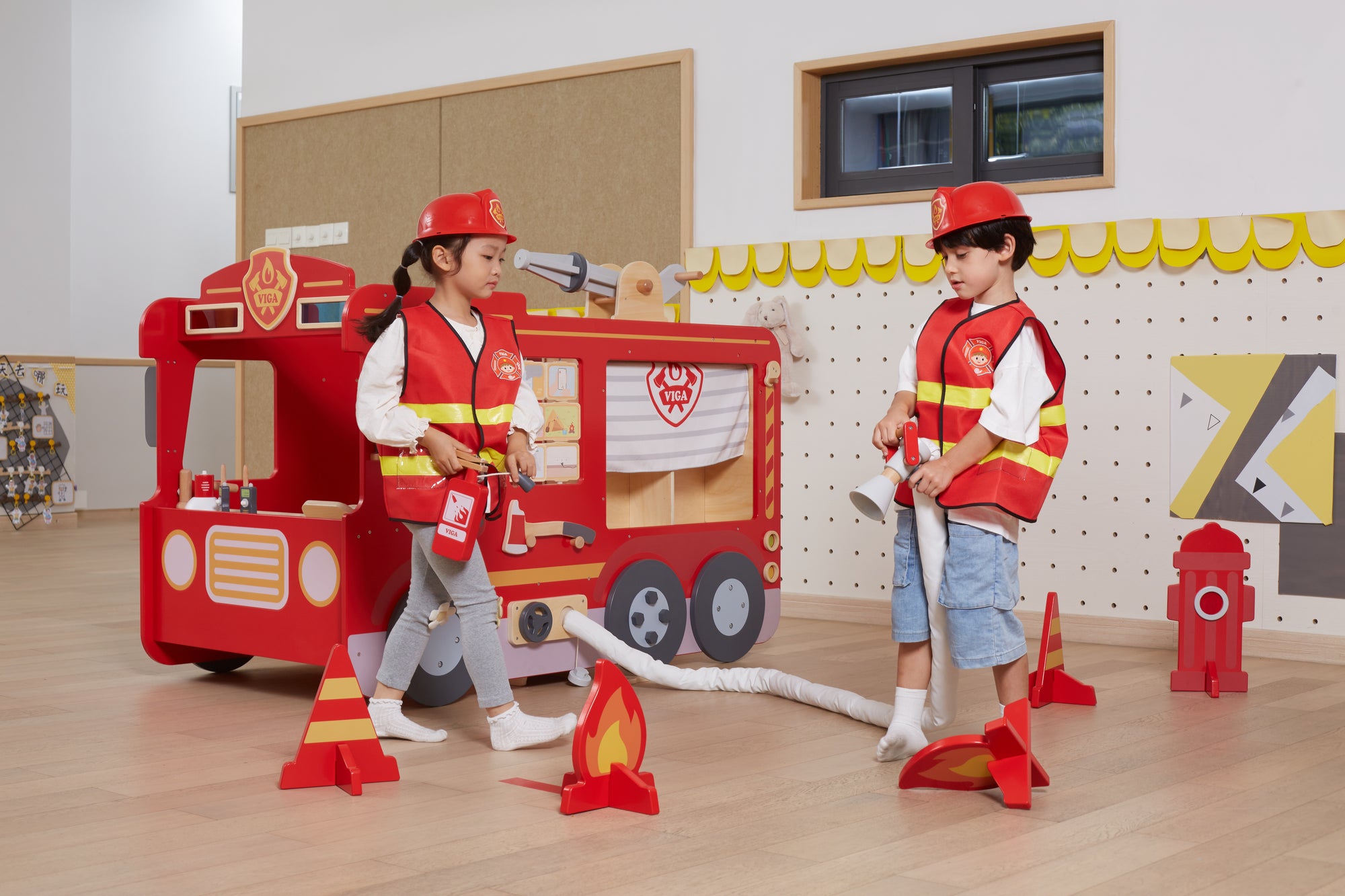 A girl and boy pretend playing with the Viga Super Fire Engine Set