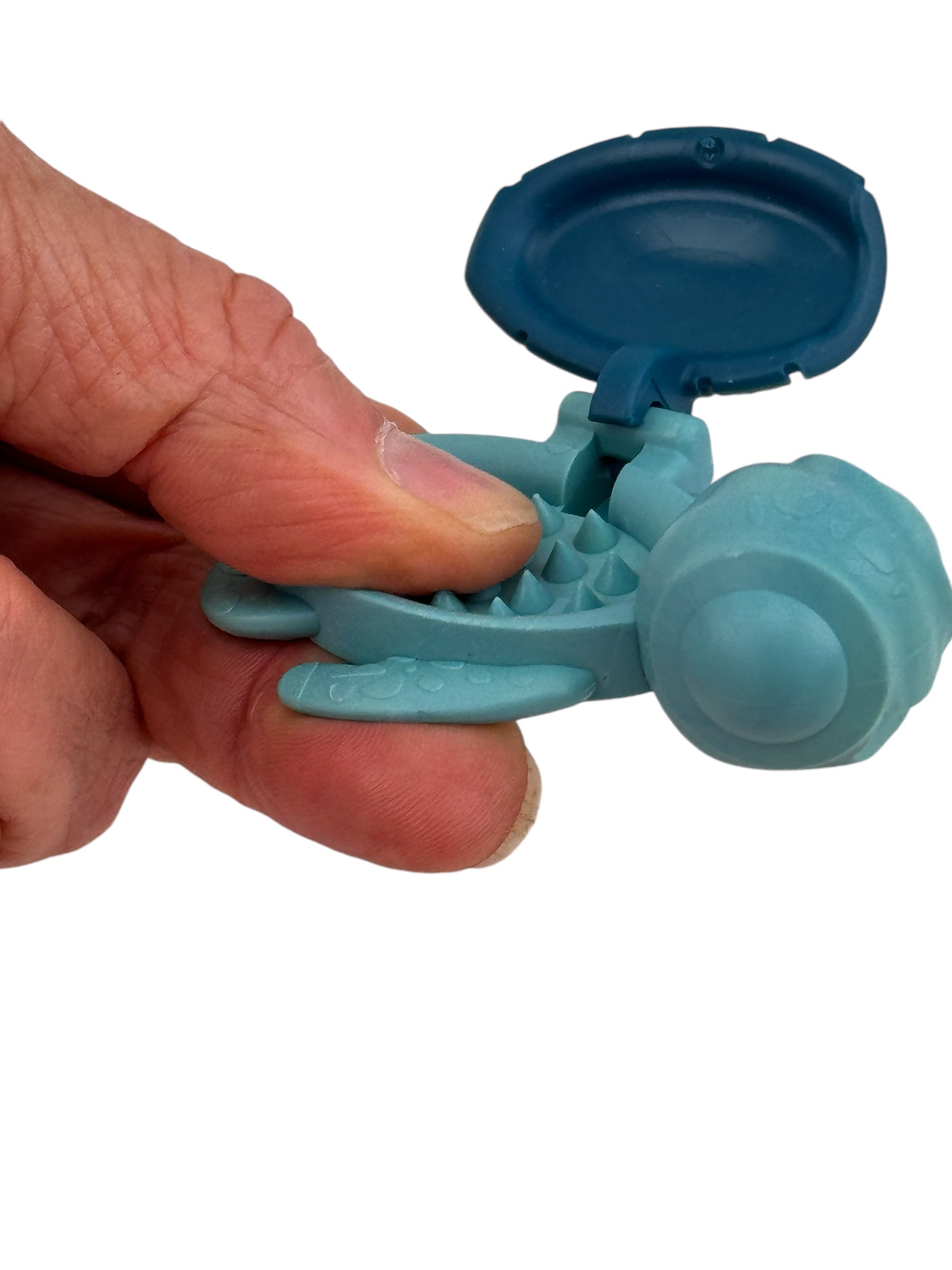 A hand pinching the thumb into a Calm Buddi Turtle