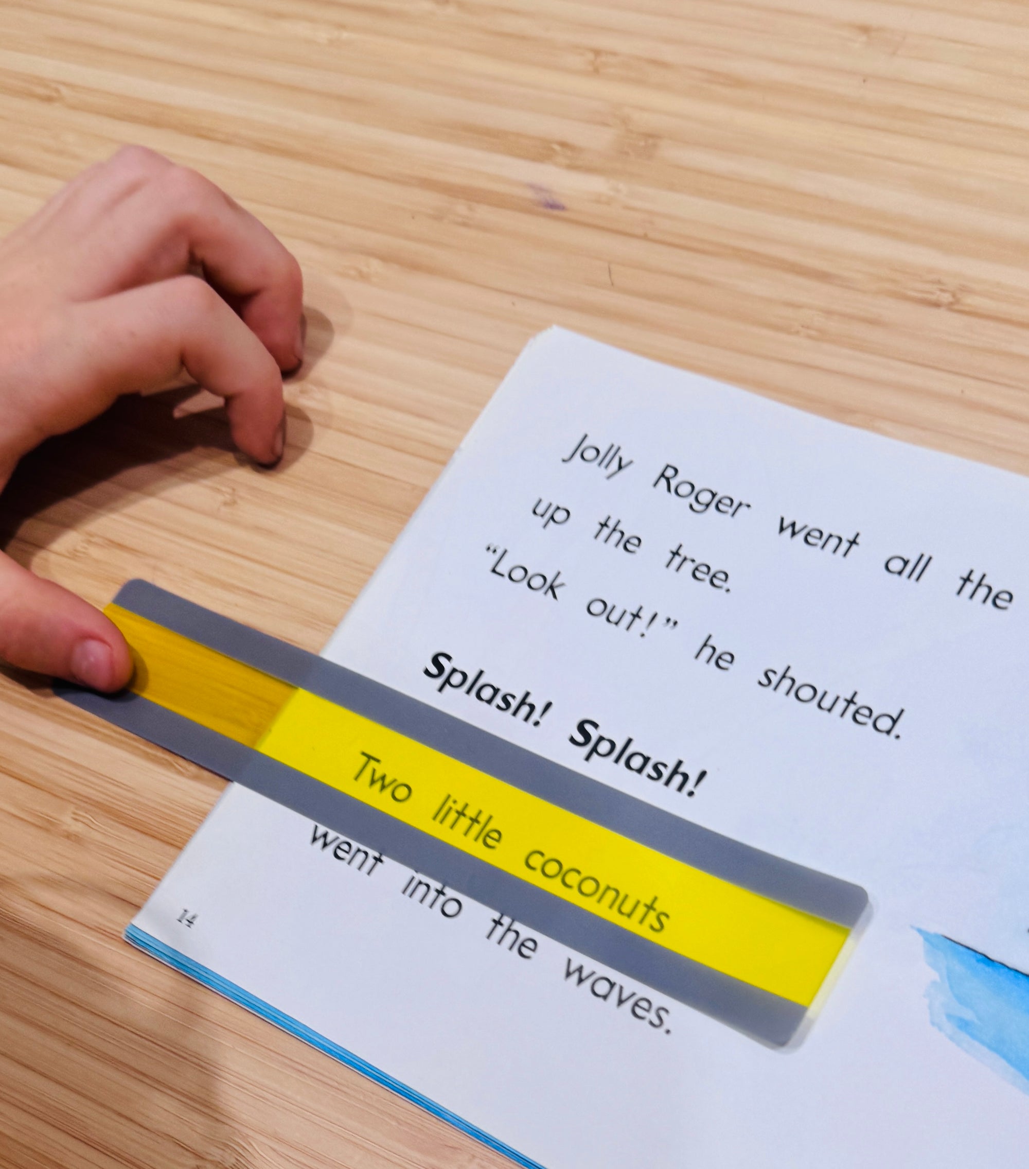 Book with a yellow and gray magnetic bookmark on a wooden surface