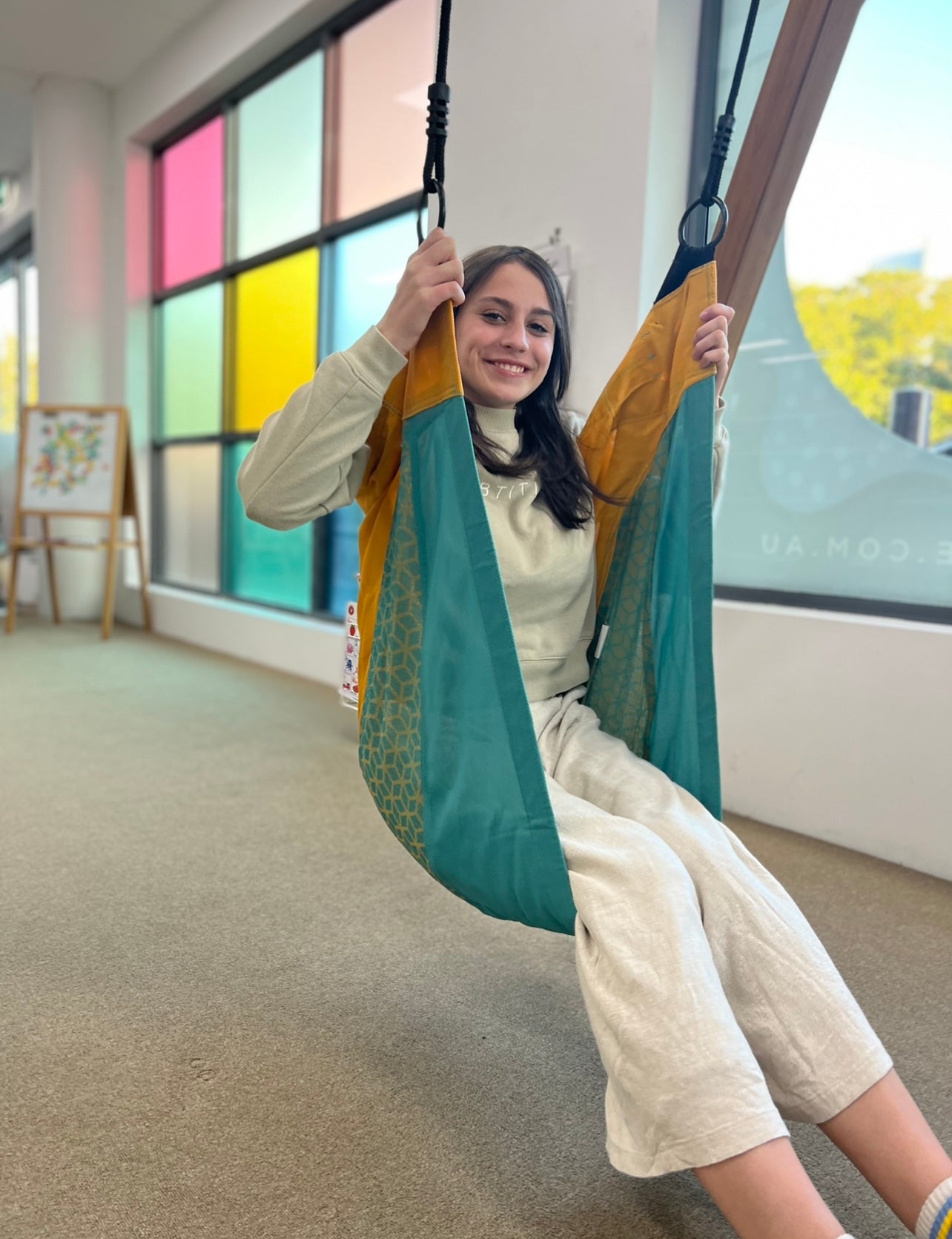 A woman sitting in the KBT Cocoon Seat Swing