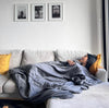 a woman sleeping on the couch using the Woosah Weighted Blanket - Bamboo
