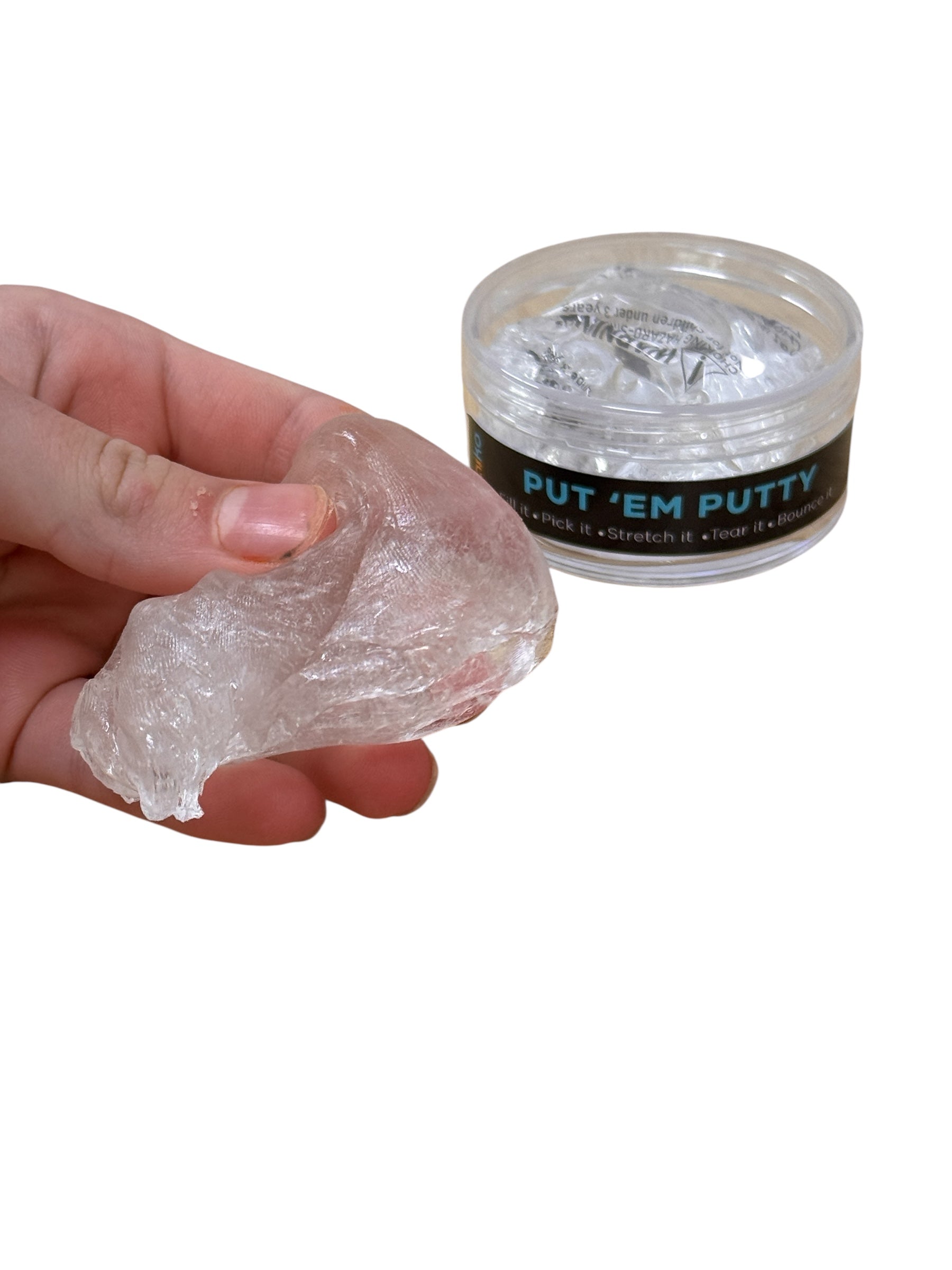 Hand holding a clear putty next to a container labeled Kaiko &#39;Put &#39;Em Putty&#39; on a white background
