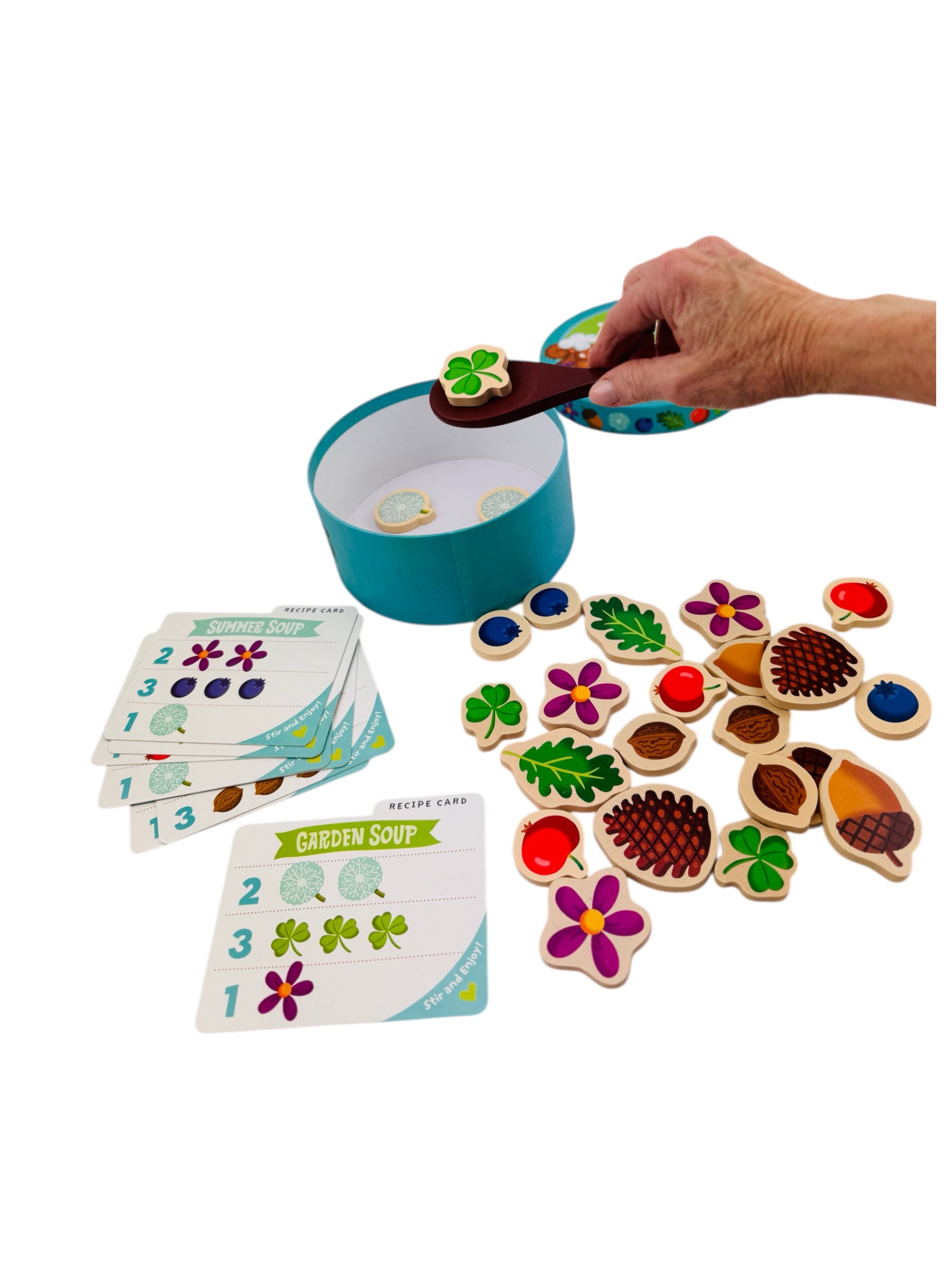 Colourful wooden puzzle pieces and cards on a white background all from the Peaceable Kingdom Acorn Soup game
