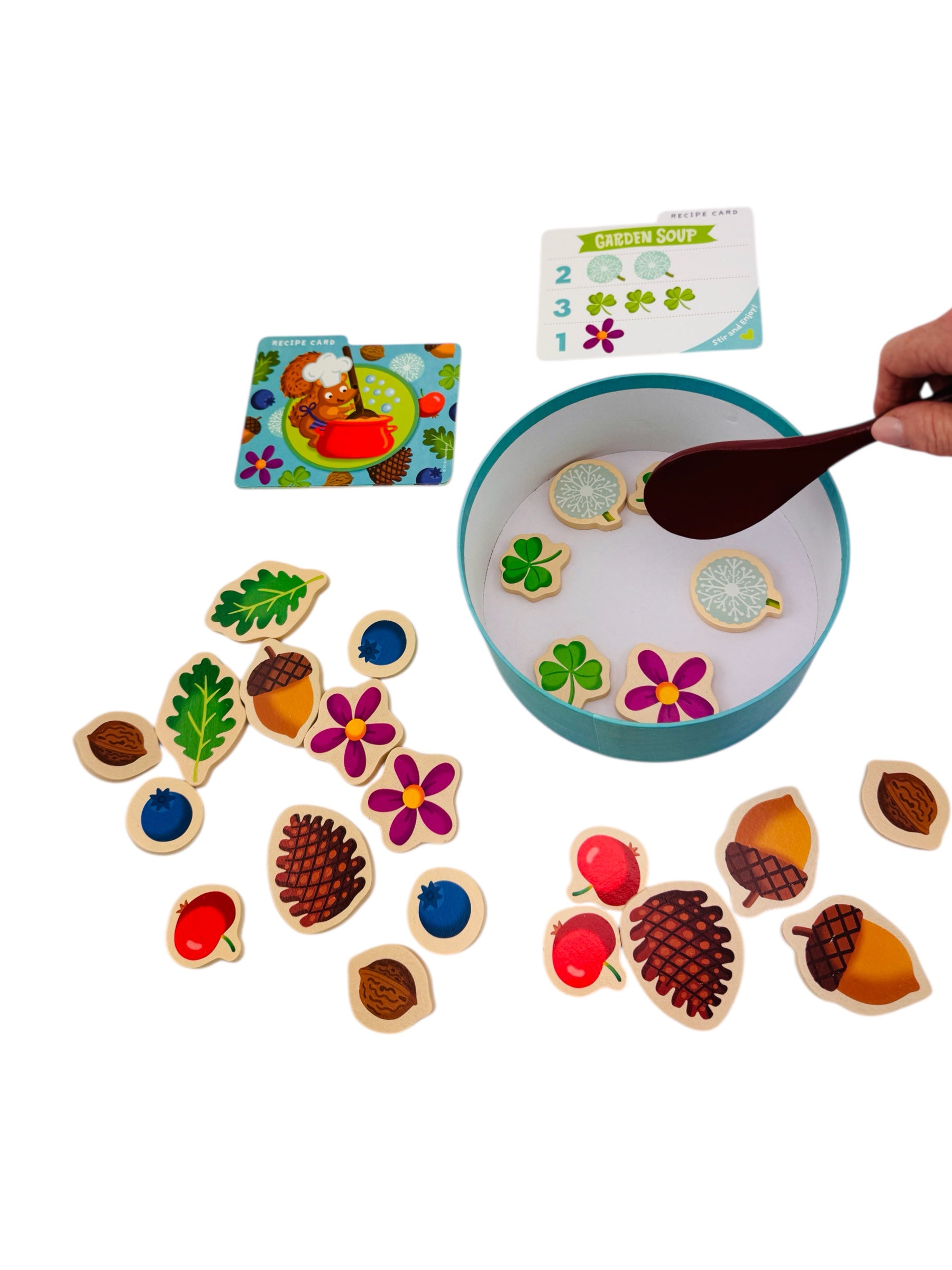 Children&#39;s educational game -Peaceable Kingdom Acorn Soup with wooden nature-themed pieces and a bowl of water.