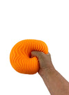 a hand squishing the orange Super Nee Doh - Ripples