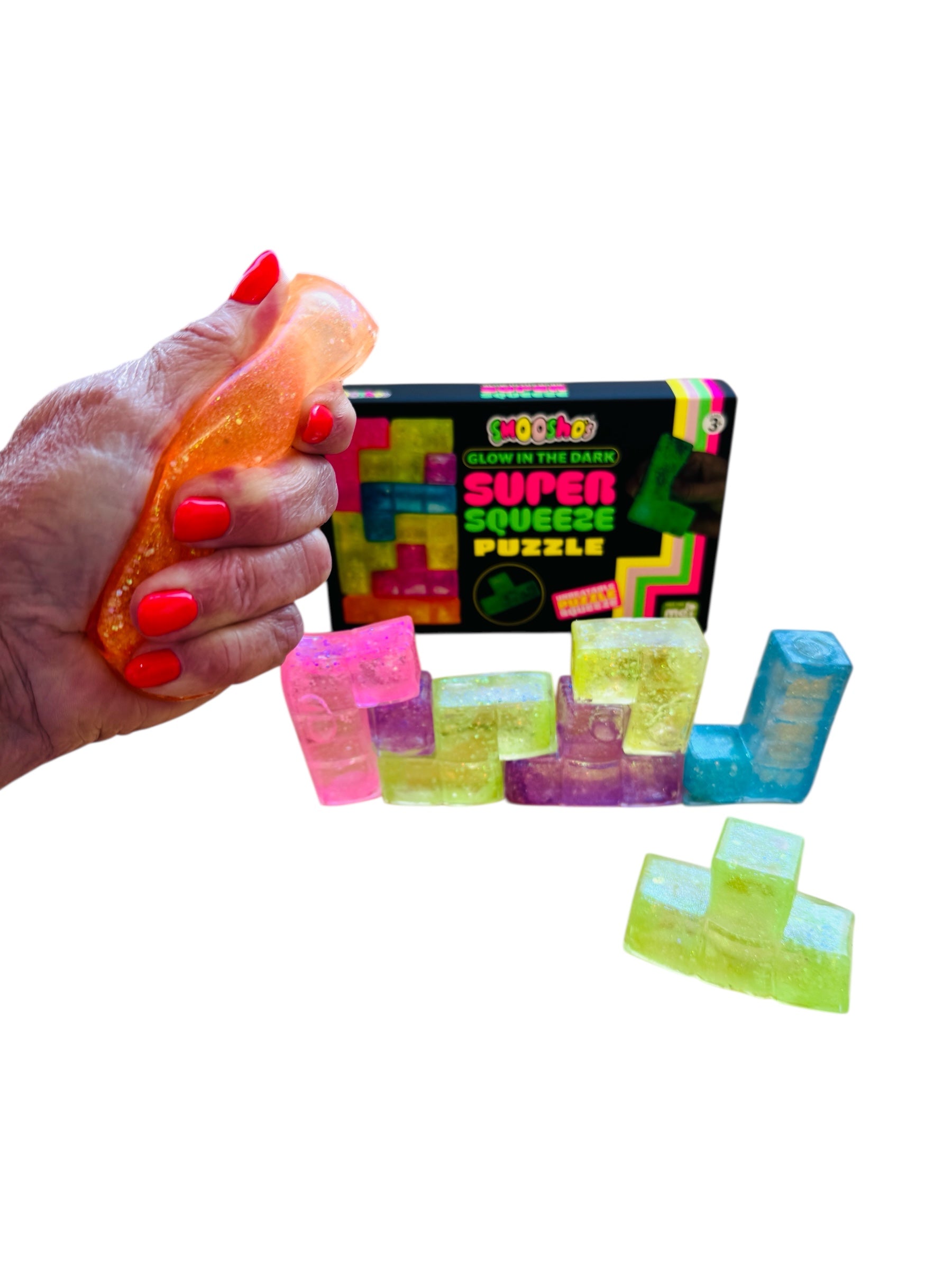 Colorful square stress relievers with a hand squeezing one and a box labeled 'Super Squeeze Puzzle' in the background.