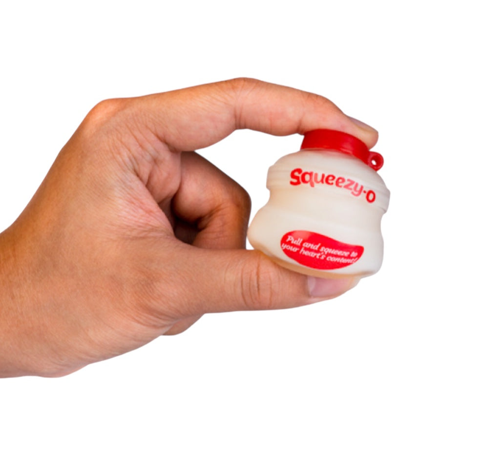 A hand squeezing the Smoosho Yoghurt Stress Ball