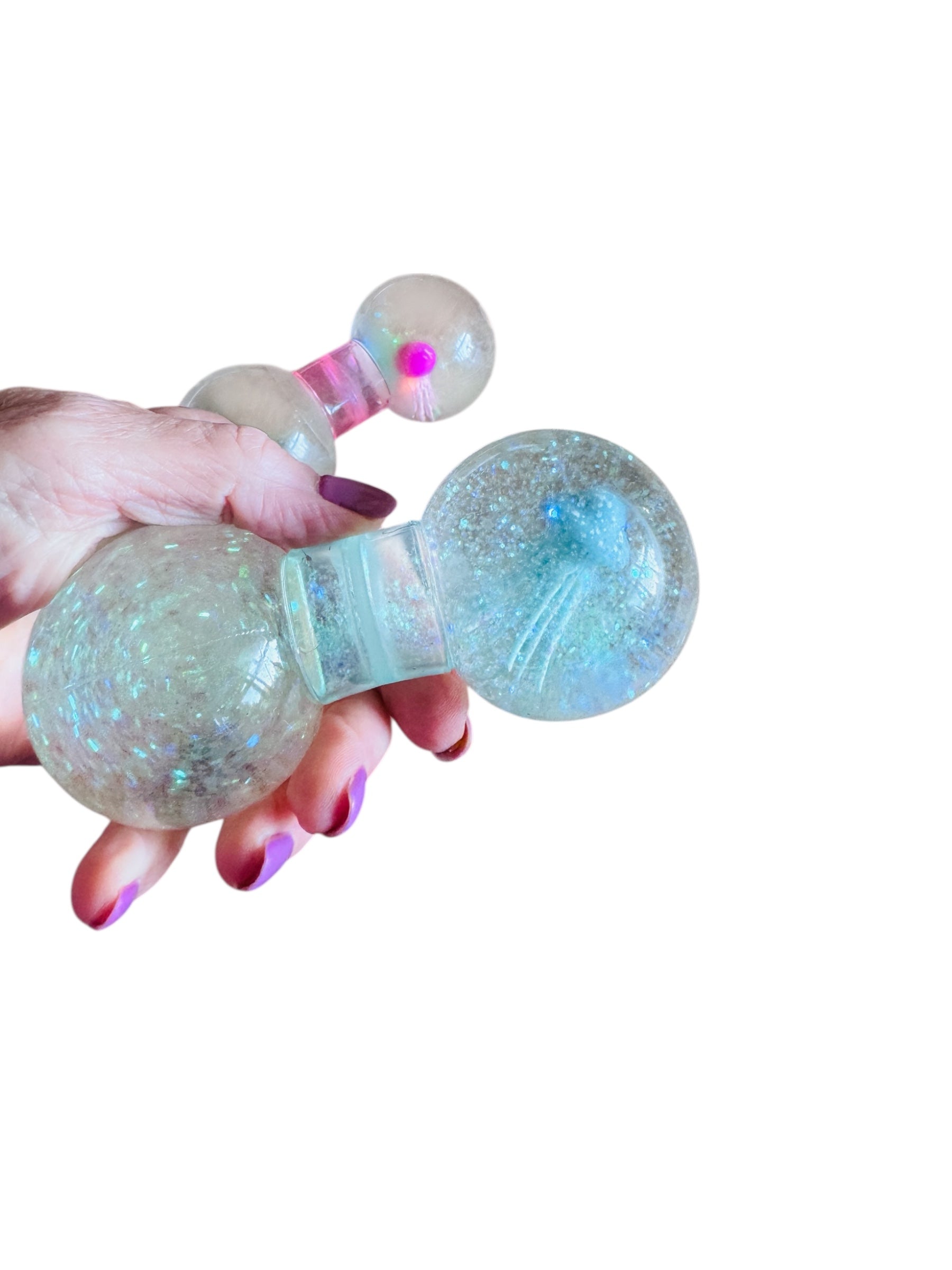 a hand holding two of the Smooshos Squishy Dumbbell - Jellyfish