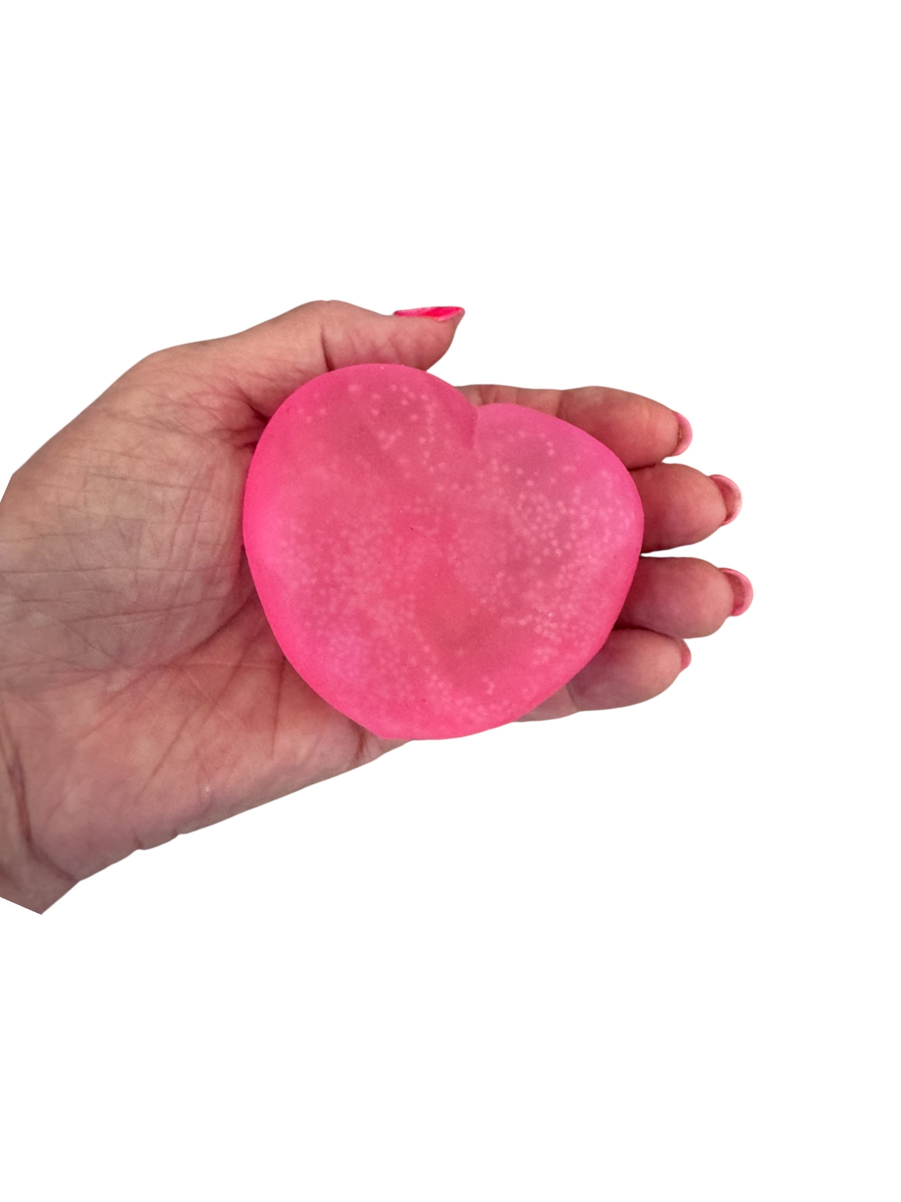 A hand holding the pink Smooshos Super Squeeze - Heart