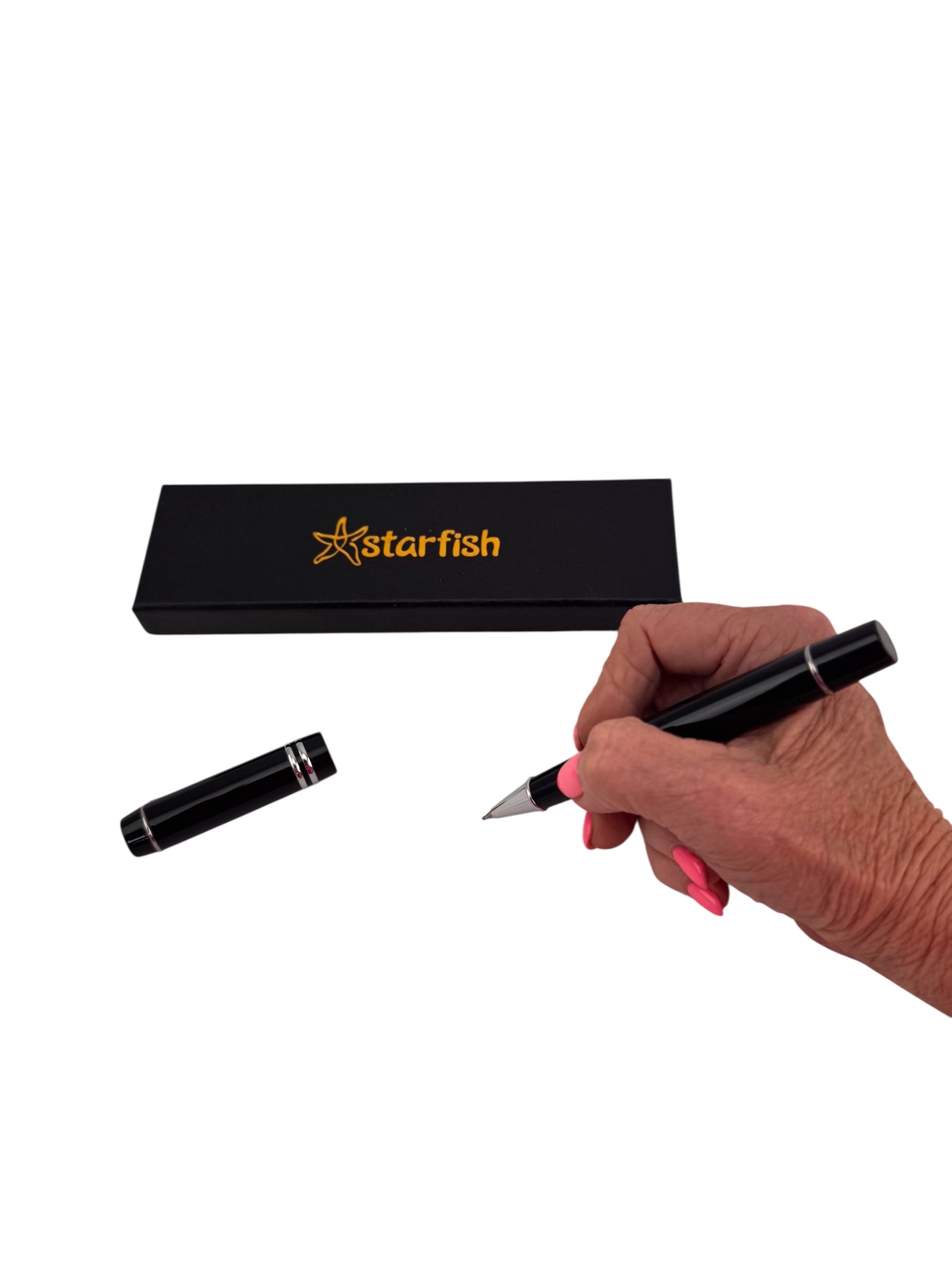 a hand holding the 70g Starfish Weighted Pen in front of it's stylish packaging