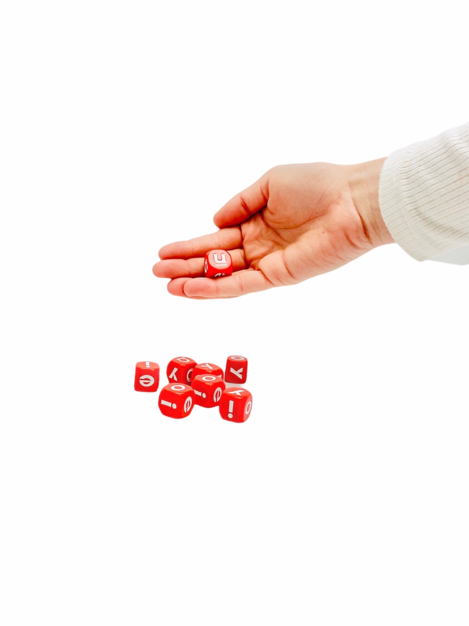 Hand holding 1 6 sided Vowels Dice on white background 