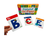 the Alphabet Go Fish! Matching Card Game on display with 3 cards in front of its box and a hand holding one of the cards
