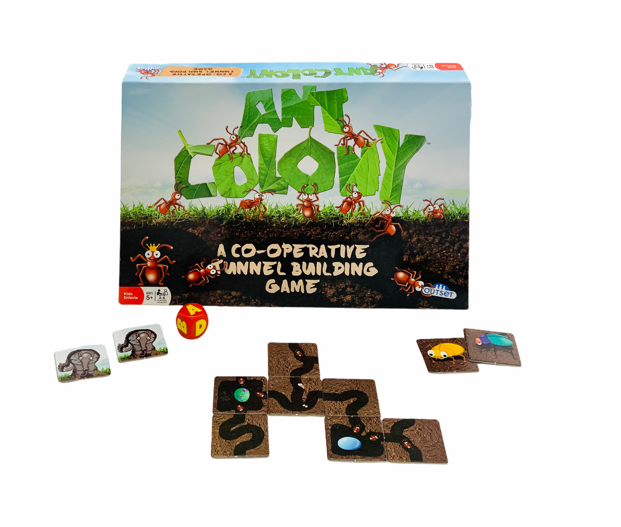 Ant Colony cooperative game with game tiles and dice laid out in front of the box on a white background