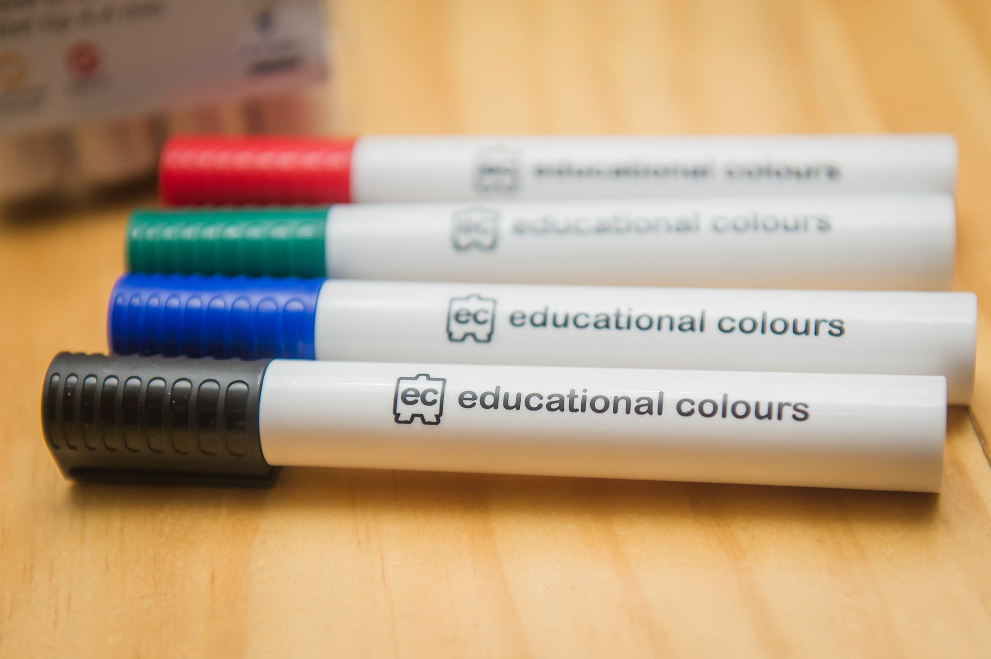 EC Whiteboard Markers in pastic storage wallet with pens placed on wooden table