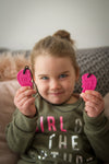 a young girl holding out the pink XT Ark Best Friends Chew