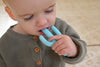 a young boy chewing on the blue Cactus Teether Toothbrush