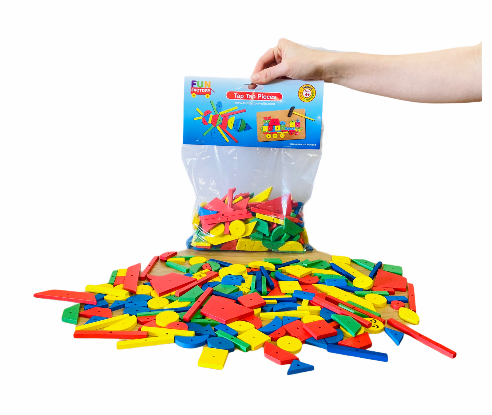 Hand holding the top of the bag with contents of theFun Factory Tap Tap Shapes laid out on white background