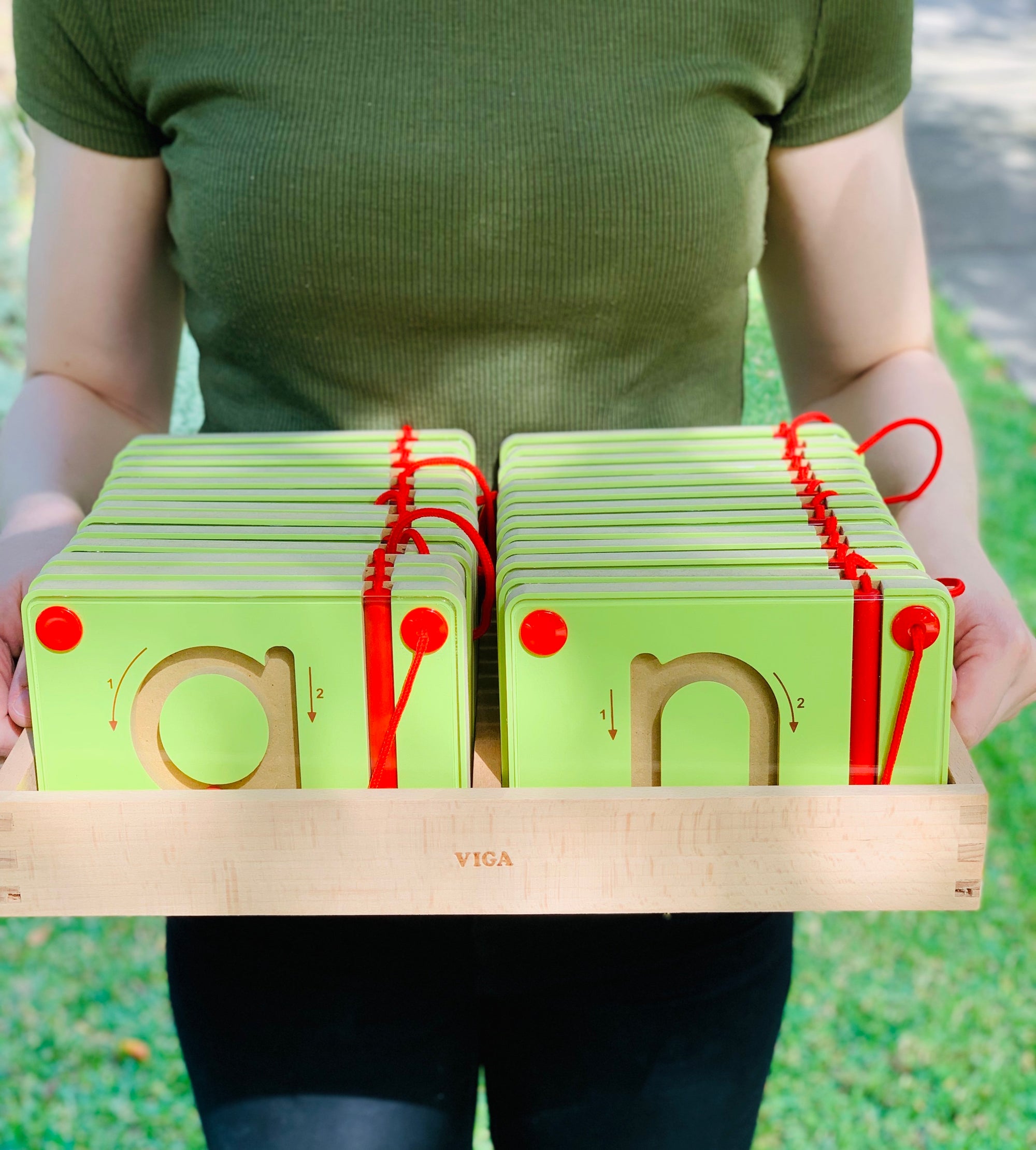 woman holding the Viga Magnetic Tracing Lower case letters