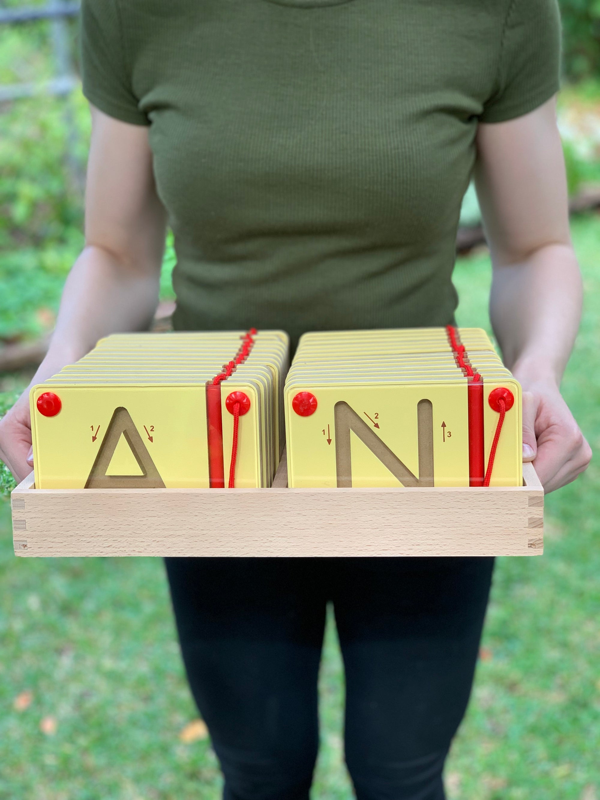 woman holding the Viga magnetic tracing upper case letters