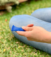 a person sitting on the grass using the blue Marble Fidget