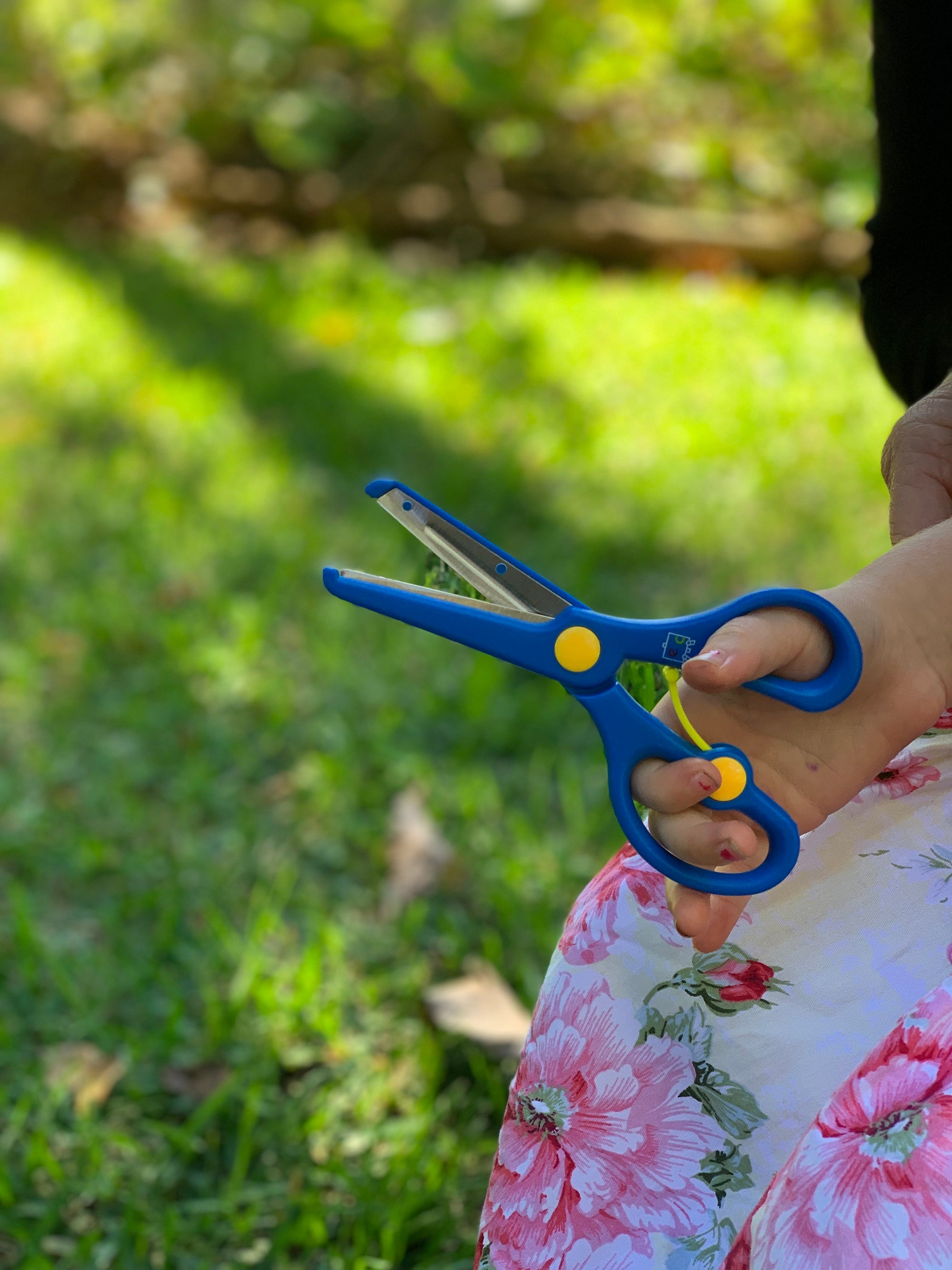 a little hand using the blue Spring back Scissors