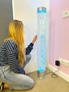 a woman touching the LED Sensory Bubble Tube - 120cm