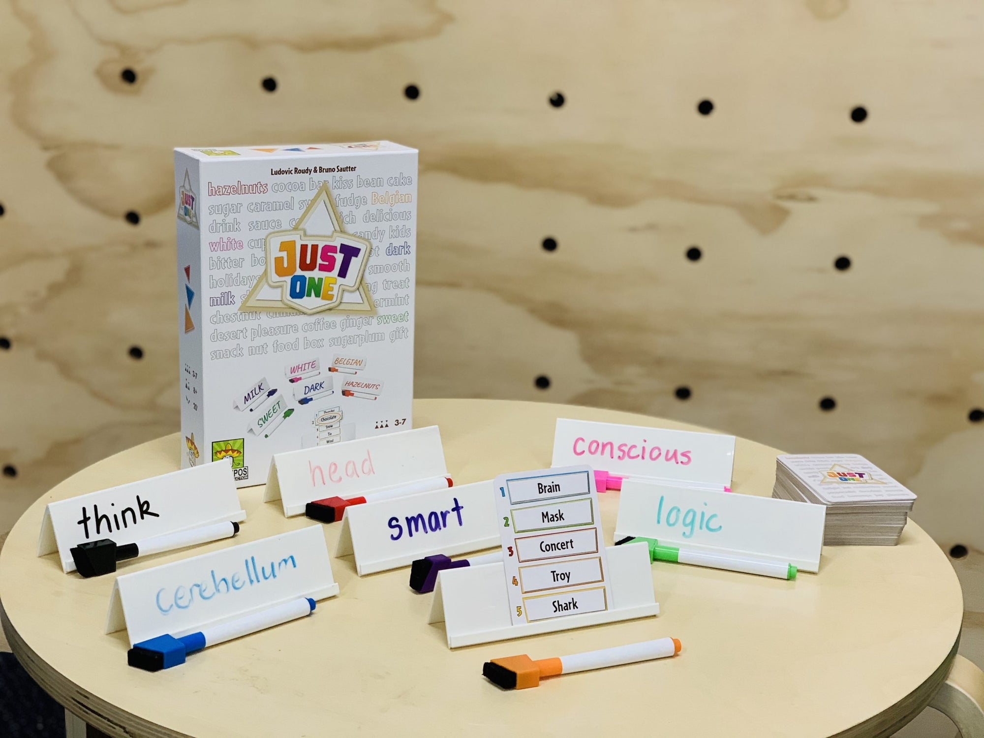 Just One game on display with contents in front of box on wooden table