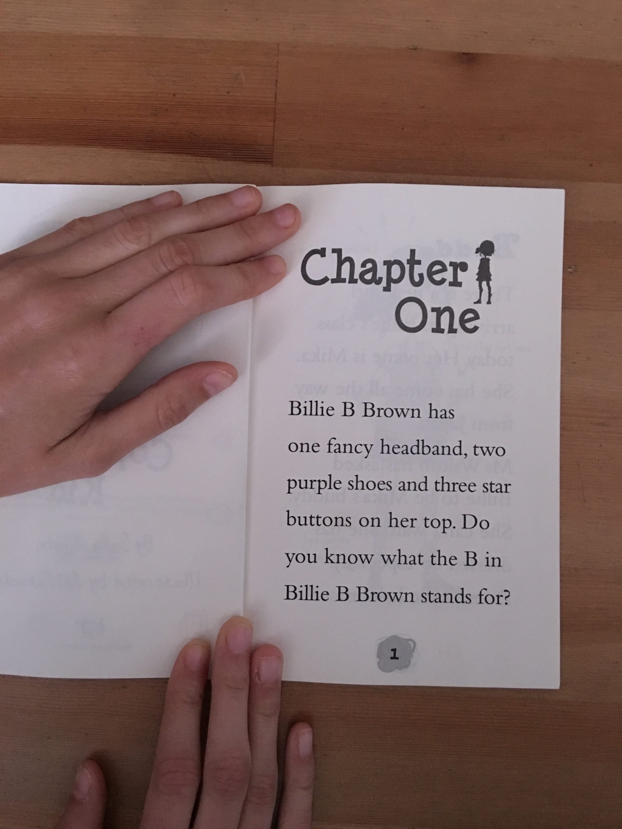 a person opening a book on wooden table