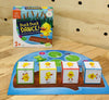 Duck duck dance game box on wooden table with game pieces laid out in front