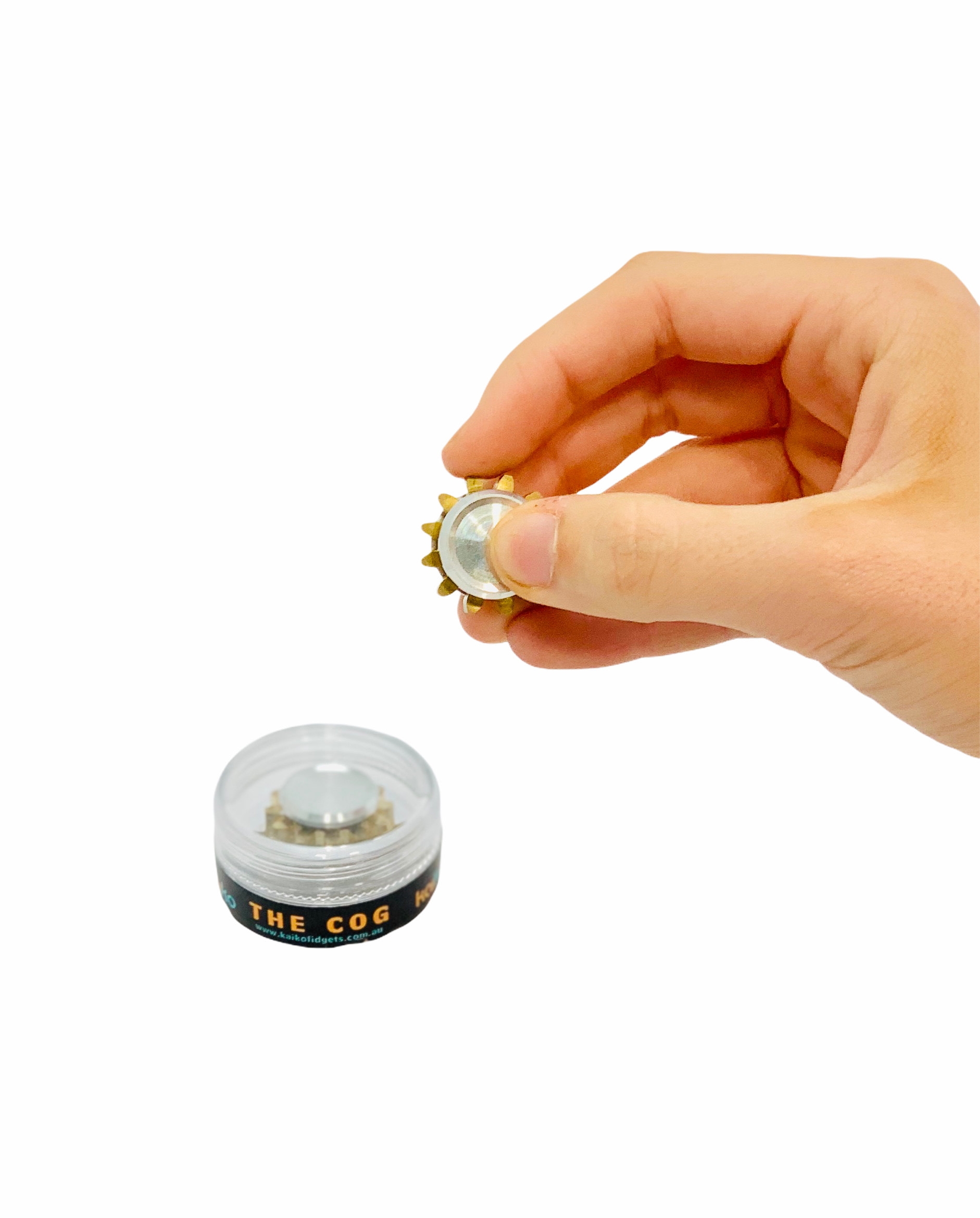 Hand holding the Kaiko Cog Fidget in front of storage box on white background
