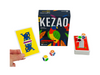 the Kezao Card Game on display with the cards and dice in front of it&#39;s box and a hand holding a yellow card