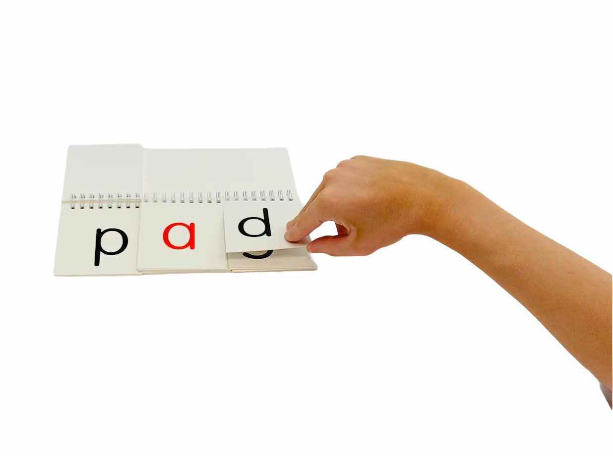 a person flipping a page from the Let's Spell! 3 Letter Words flip book