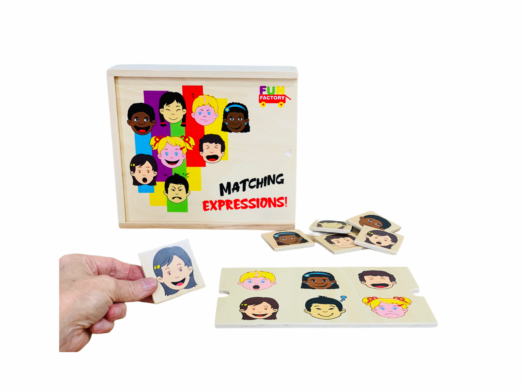 Fun Factory Matching Expressions Game with game cards laid out with wooden tiles showing facial expressions and hand holding a tile showing a happy girl