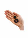 a hand holding two fidgets from the Kaiko the works Kit Black