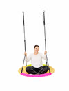 a woman in white shirt and black shorts swinging in the Round Nest Sensory Swing