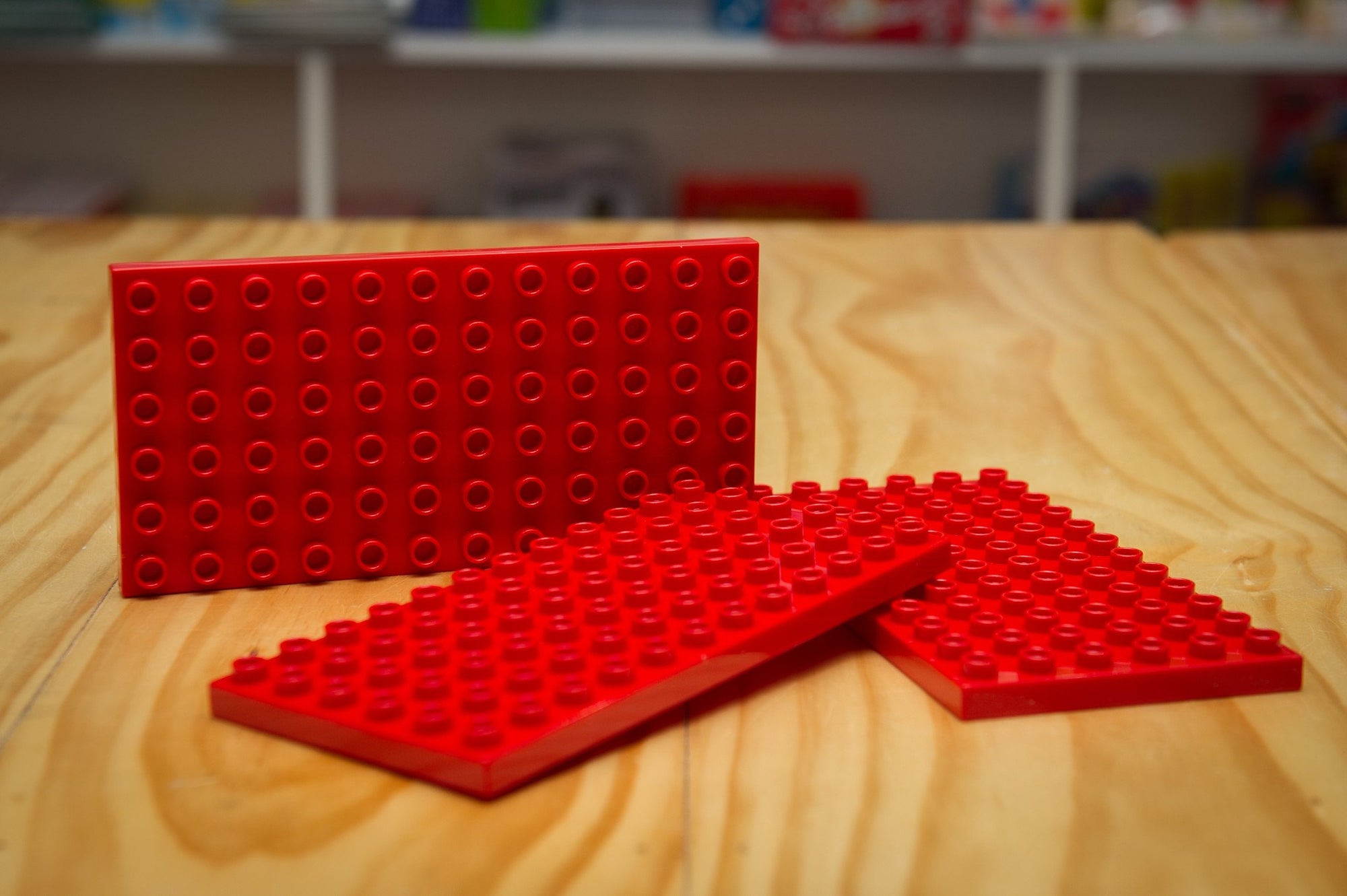 Coko Bricks Base Plate - Small in red on wooden table