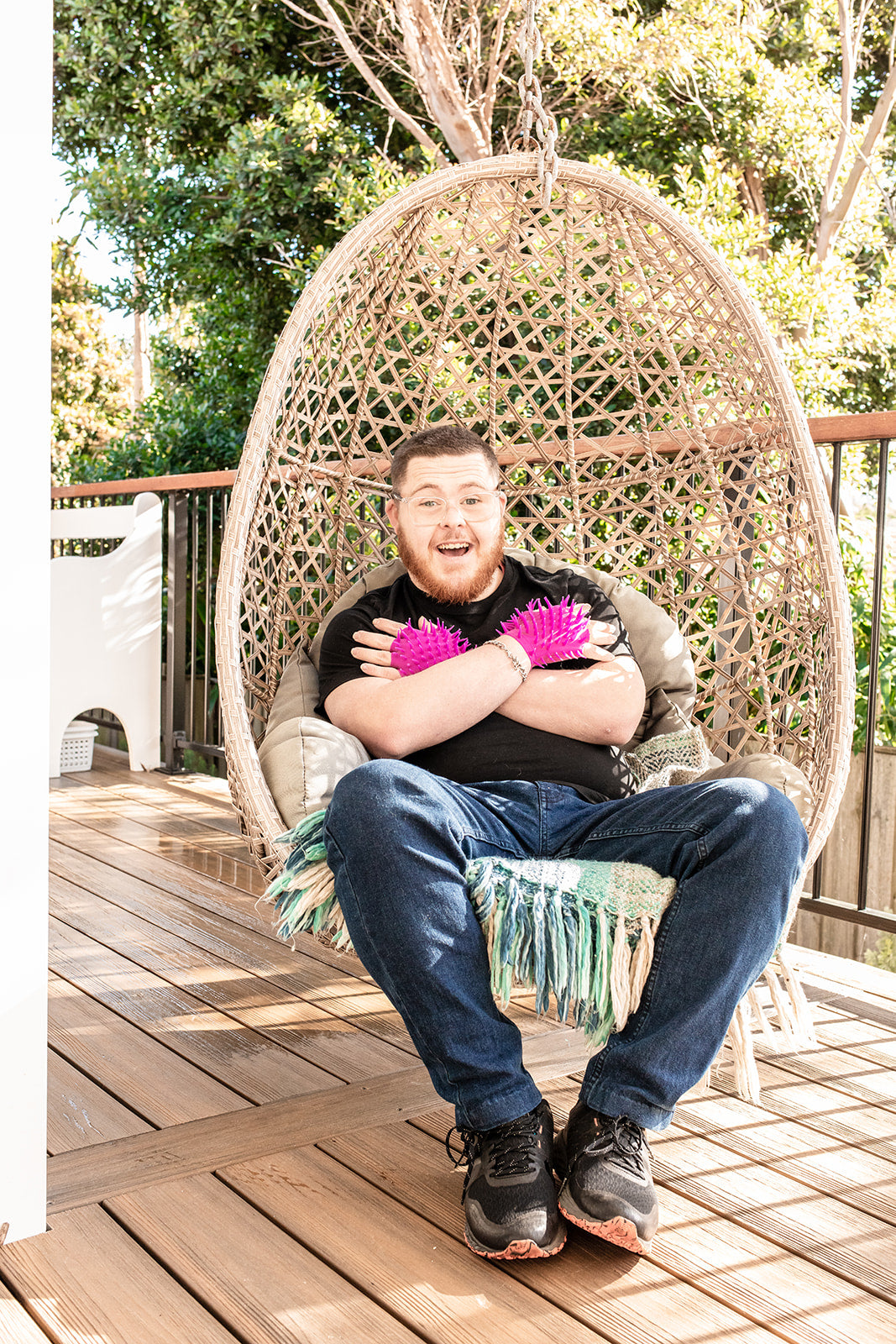 a man sitting in an egg chair wearing the Spiky Sensory Gloves