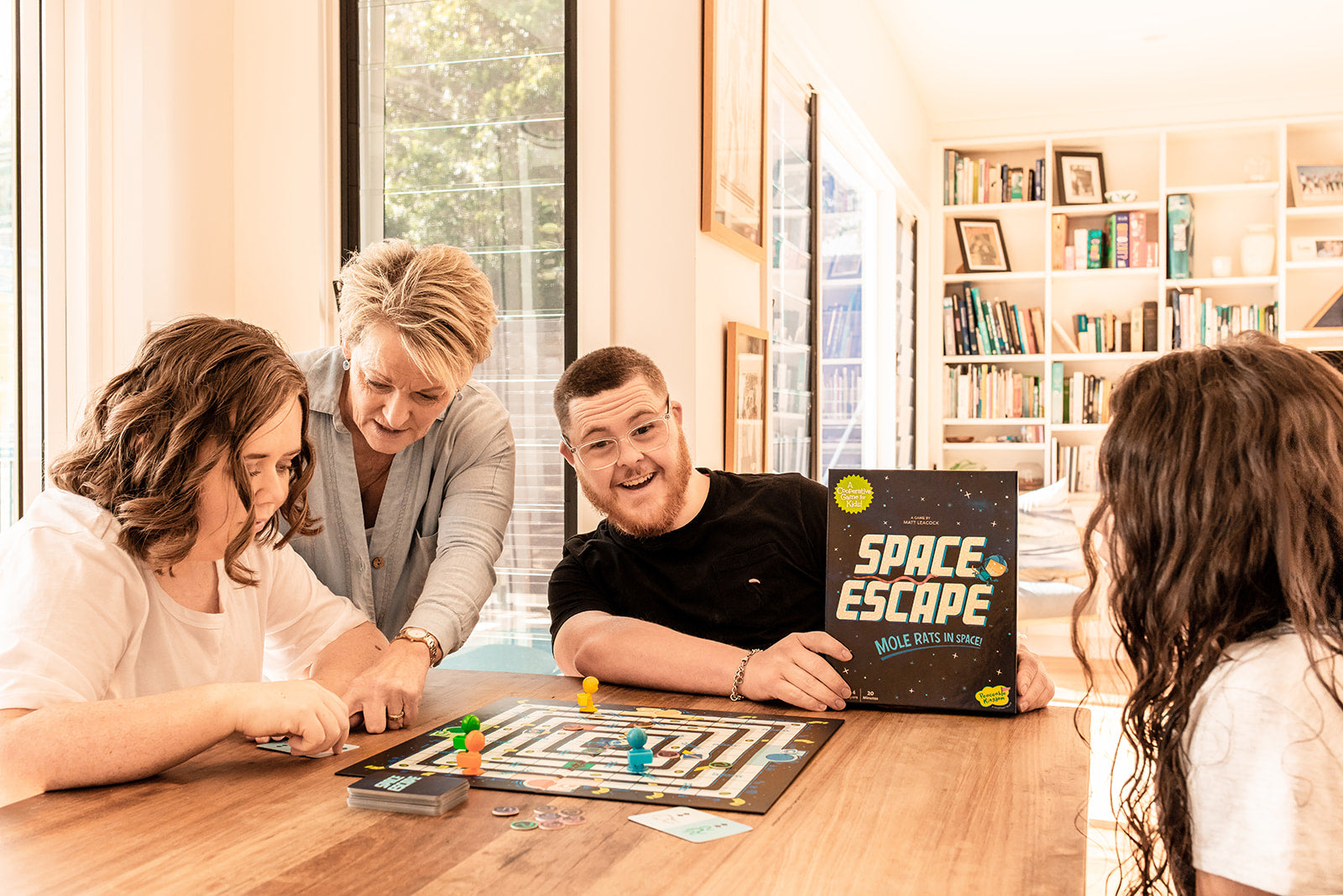 a group of people playing the Peaceable Kingdom Space Escape board game