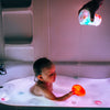 a child playing with the red Glo Pals Light-Up Cubes in the bath