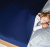 Little girl sleeping in a bed with the navy Harkla Sensory Compression Sheet - Full/Double and grey pillows